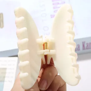 Vue macro détaillée de la pince à cheveux papillon crème avec motifs à carreaux
