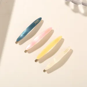 Detailed view of four colorful acetate hair barrettes with elegant gold lettering