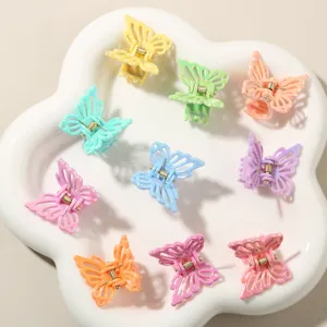 Dettaglio di mollette per capelli a farfalla colorate in un vassoio a fiore
