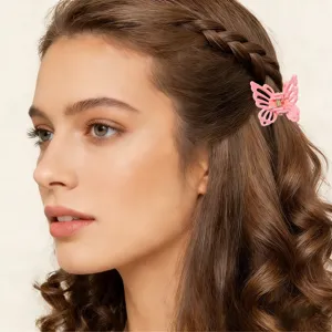 Dettaglio di una mini clip per capelli a farfalla rosa su capelli intrecciati