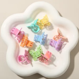Dettaglio di graziose mini mollette per capelli a farfalla color pastello in vassoio