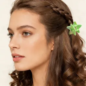 Primo piano di una piccola molletta per capelli a forma di stella verde sui capelli mossi
