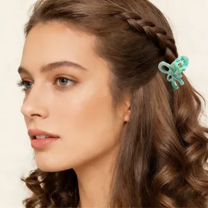 Dettaglio di una mini molletta per capelli a farfalla verde chiaro da 2,5 cm in una treccia