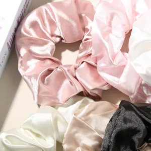 Detailed macro shot of elegant large faux silk scrunchies in assorted pastel colors