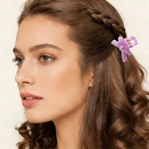 Vista dettagliata di una mini pinza per capelli viola da 2,5 cm su capelli bruni.