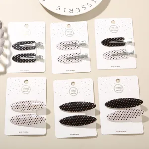 Detail view of acetate polka dot duckbill hair clip sets on white display cards