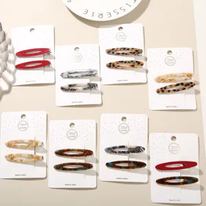 Assorted acetate hair clips with leopard and marble patterns on white display cards