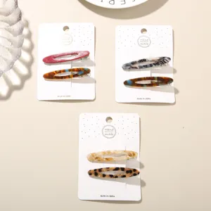 Detail view of acetate hair clip sets in various marble and tortoiseshell patterns.