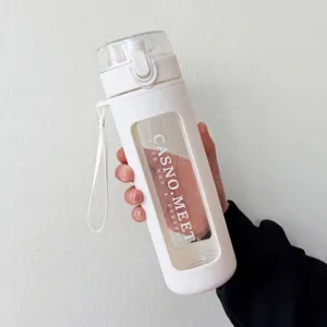 Primer plano de una botella de agua portátil de vidrio blanco con funda