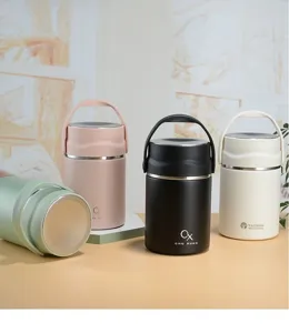 Nahaufnahme von minimalistischen Thermobehältern in Creme-Farben mit praktischen Tragegriffen.