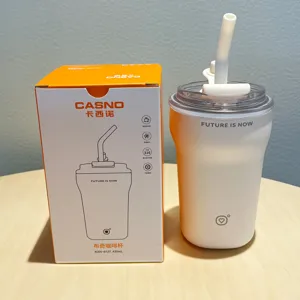 Close-up of insulated coffee cup with straw alongside its orange and white retail box packaging