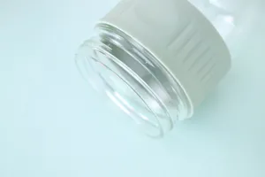 Λεπτομερής μακροεντολή του χείλους γυάλινου βάζου και πράσινης θήκης σιλικόνης