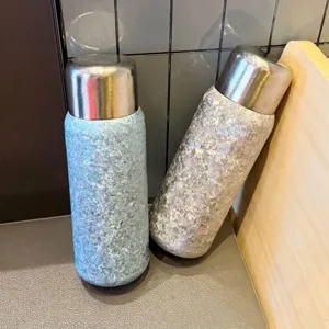 Vista detallada de las botellas térmicas de 550ml de titanio puro con textura de flor.