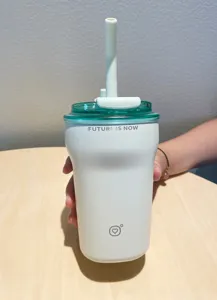 Minimalist insulated coffee cup with white straw and 'Future is Now' printed slogan.