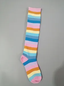 Detailed view of colorful rainbow striped knee high socks made from soft cotton material.
