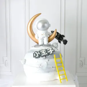 Dettaglio decorazione torta con astronauta sulla luna e scaletta gialla per compleanno