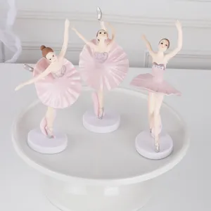 Gedetailleerd overzicht van drie roze balletmeisjesbeeldjes voor taartdecoratie op standaard