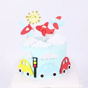 Dettaglio di topper per torta a tema trasporti con aereo e auto in schiuma EVA