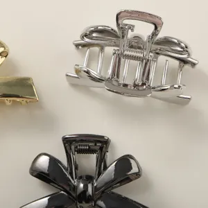 Detail showing minimalist metal bow hair claw clips in silver, black and gold.