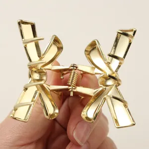 Close-up detail of golden bow hair claw clip showing metal texture