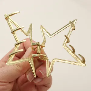 Close-up of golden star-shaped hair claw clip showing spring mechanism