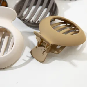 Dettaglio macro che mostra la finitura opaca e il design cavo delle pinze per capelli tonde