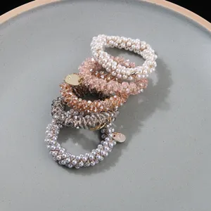 Detailed view of hand-woven crystal beads and faux pearls on elastic hair ties