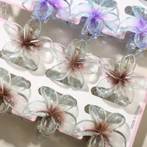 Detail of 4cm glittery flower hair clips in blue and grey gradient on white card