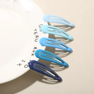 Detailansicht von fünf blauen Verlaufs-Haarclips, elegant auf weißem Teller angeordnet