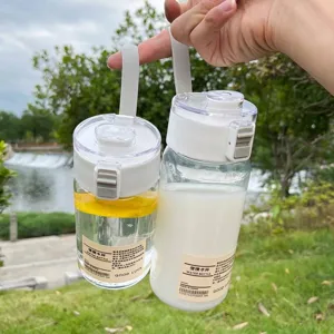 Paar minimalistische Plastikwasserflaschen mit Trageriemen in einem Park im Freien
