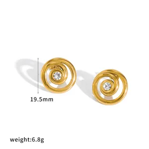 Detailed view of gold-tone spiral earrings featuring a sparkling central rhinestone accent.