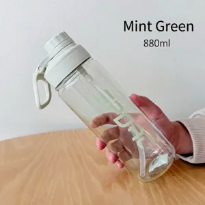 Mano sosteniendo botella de agua deportiva transparente verde menta de 880 ml con pajita