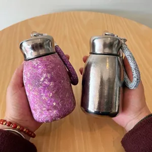 Κοντινό πλάνο φορητών φιαλών τιτανίου σε μωβ και ασημί χρώμα στα χέρια