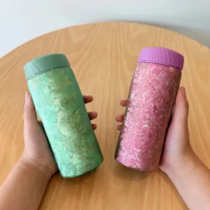 Nahaufnahme von Reintitan-Isolierbechern mit rosa und grüner Eisblumen-Oberfläche