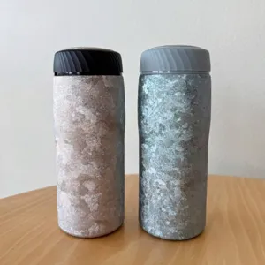 Zwei Thermobecher aus Titan mit Eiskristall-Textur auf einem Holztisch