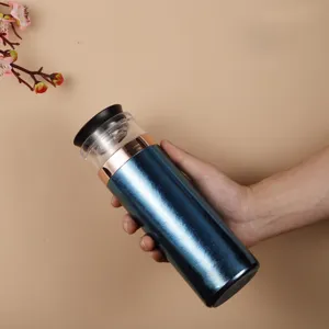 Hand hält eine 470 ml Teeflasche in Metallic-Blau mit transparentem oberen Bereich