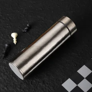 Hochwertige silberne Titan-Isolierflasche auf schwarzem Untergrund mit Schachfiguren
