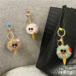 Detailed view of plush ice cream cone keychains hanging on a black bag and chair.