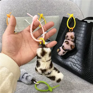 Close-up of stylish leopard print plush pendants with colorful twist ring attachments for bags