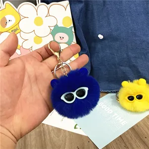 Close-up of cute blue plush soot sprite keychain with sunglasses bag charm decoration