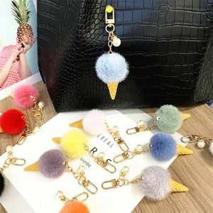 Detail view of colorful plush ice cream keychains with pearl accents and gold chains.
