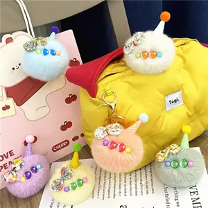 Colorful assortment of fuzzy ice cream scoop keychains with party hats and bows