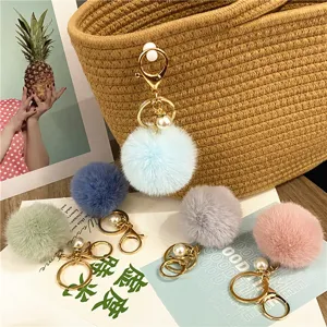 Close-up of cute plush ball keychains in pastel macaron colors with pearl detail