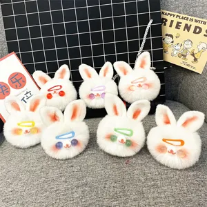Set of cute white plush bunny keychains with colorful clips on a cozy background.