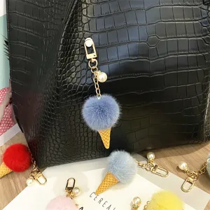 Macro detail of cute blue plush ice cream keychain charm hanging on black leather bag