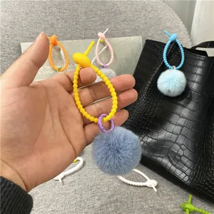 Close-up of creative candy-colored plush pom-pom keychain with a flexible silicone loop.