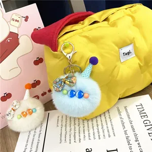 Detail of cute plush pom-pom keychains with colorful ice cream cone hats and bows