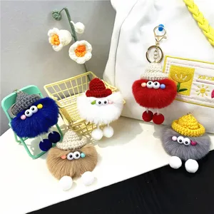 Detailed macro view of five colorful plush monster keychains with knitted hats