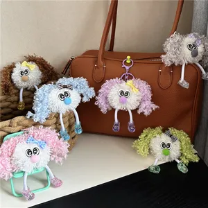 Group of colorful cute curly plush doll keychains hanging on a brown leather bag.