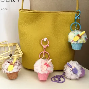 Close-up of colorful cute ice cream plush keychains hanging on a stylish yellow bag